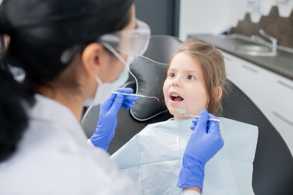 детский стоматолог осматривает ребенка